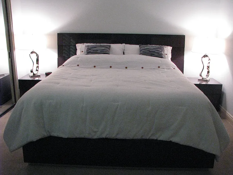 Secondary bedroom 2 that has corner windows. King bed and large sitting chair.