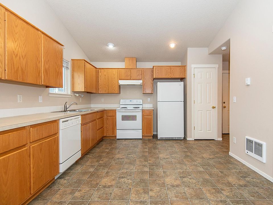 Large open kitchen with lots of cabinets and counter space and a vaulted ceiling - pantry next to the refrigerator.