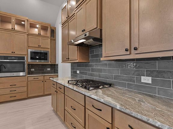 Kitchen with many wood cabinets and tile backsplash