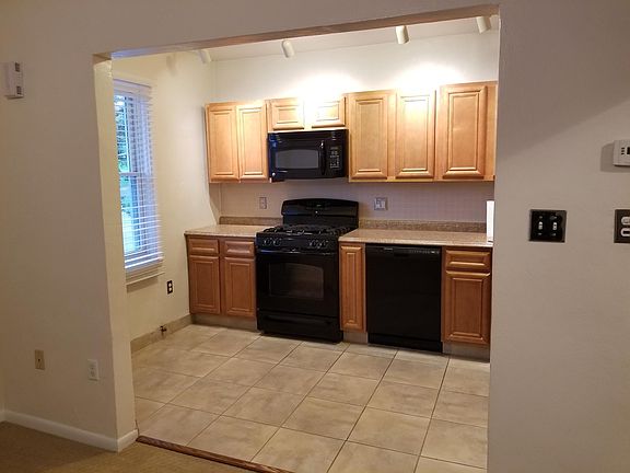 Kitchen left half view from living room. Gas stove, microwav