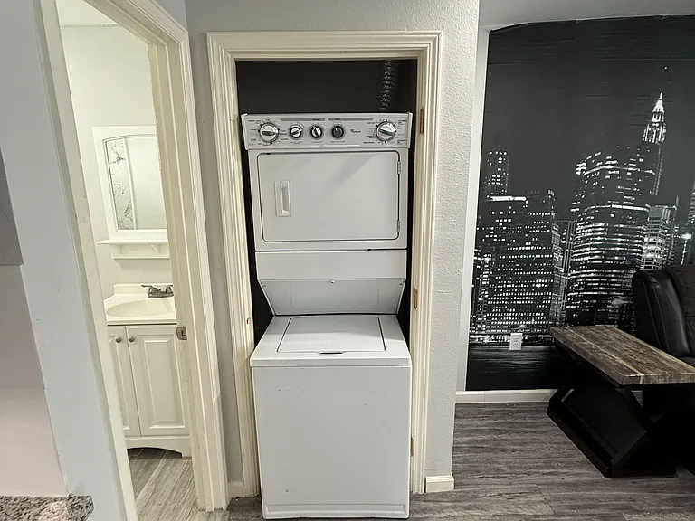 Convenient in-home laundry closet with a stacked washer/dryer, located off the main living area for easy access.