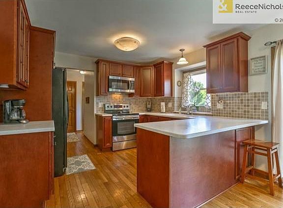 Hardwood floors, along with custom cabinets, tiled backsplash an