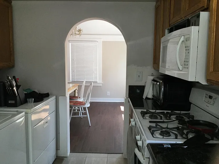 Kitchen with all appliances, including washer/dryer, leading to dining room.