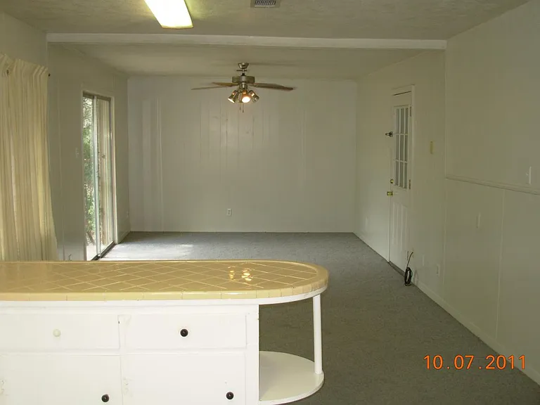 Den showing Patio Doors to Back Yard and Door to Utility Roo