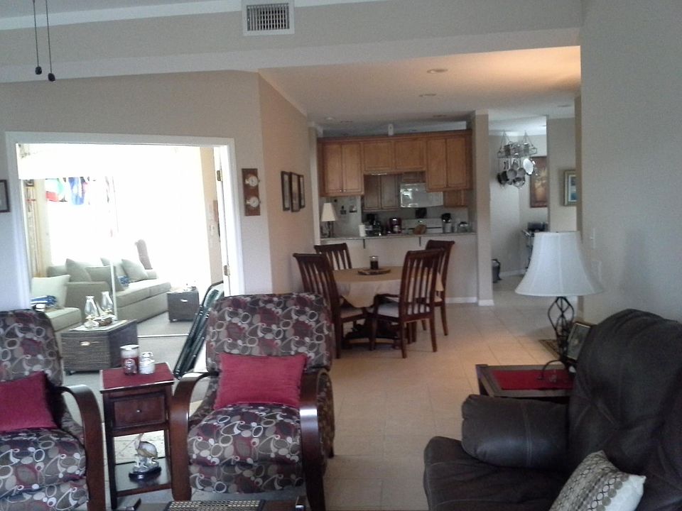 Den, 2nd bedroom to left, with dining table and kitchen at r