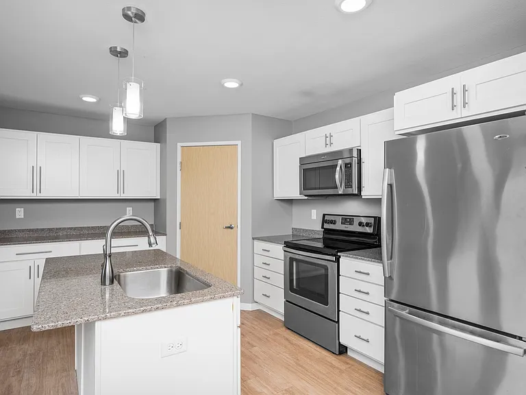 Modern kitchen with stainless steel appliances, granite countertops, and stylish pendant lighting. Modern kitchen with stainless steel appliances, granite countertops, and stylish pendant lighting.