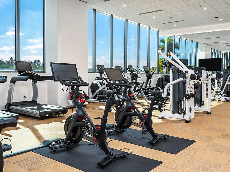 Peloton bikes and premium cardio equipment support an elevated fitness routine.