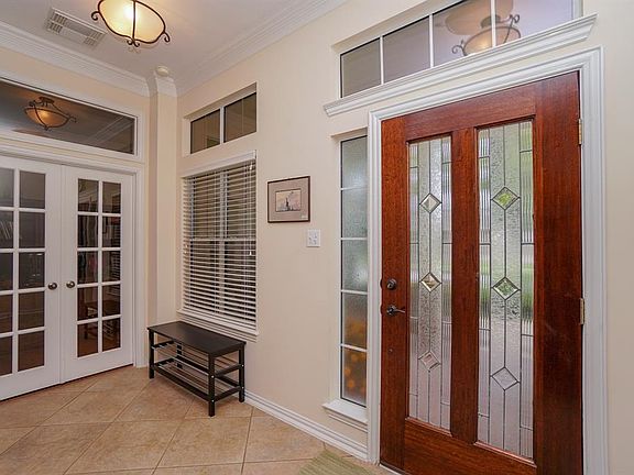 Grand foyer with transom windows allowing natural light to flow into the home