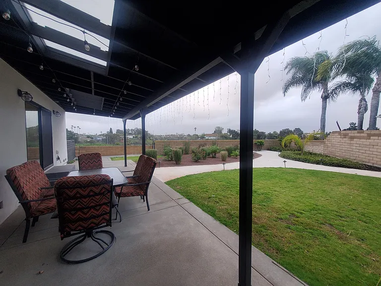 Back patio with cafe lighting and patio furniture which seats 6