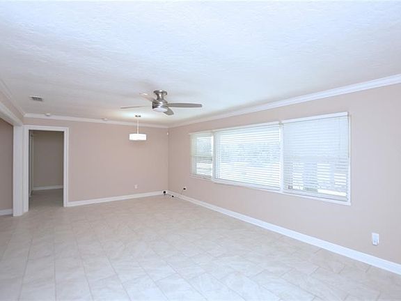 Light & bright living area with crown molding and tile flooring for easy care.
