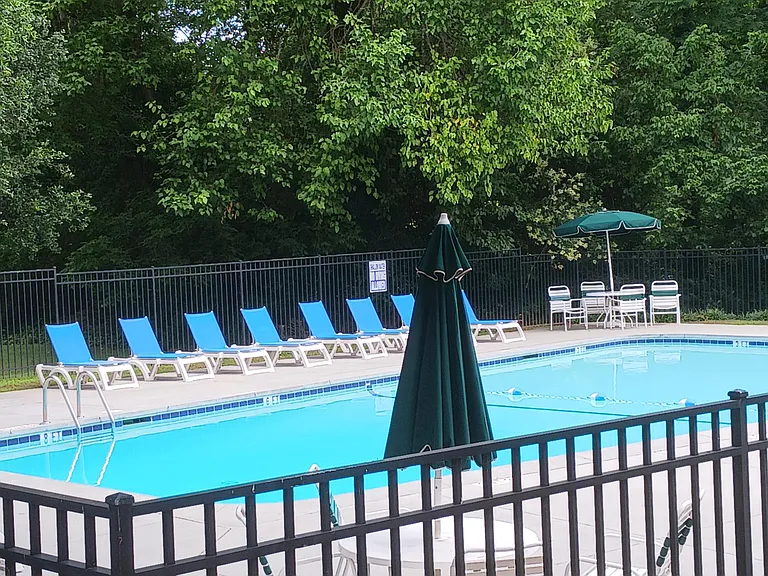 Second pool is to the left of the community building with tables and lounge chairs.