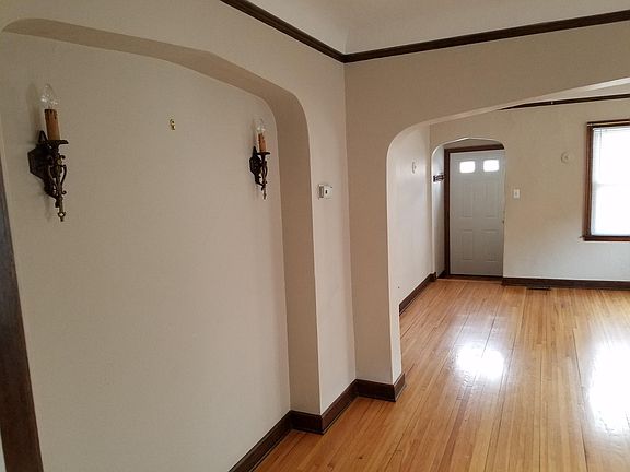 Original wall sconces on the left. Front door straight ahead. Front windows facing 28th Ave. The apartment is situated on a hill away from the street. This and the sound proof windows keeps the place quiet.