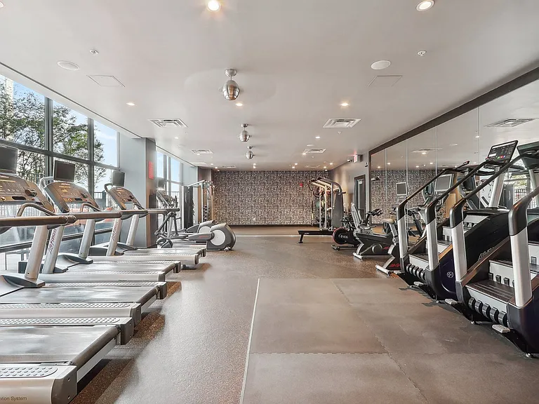 fitness center with cardio equipment and large windows