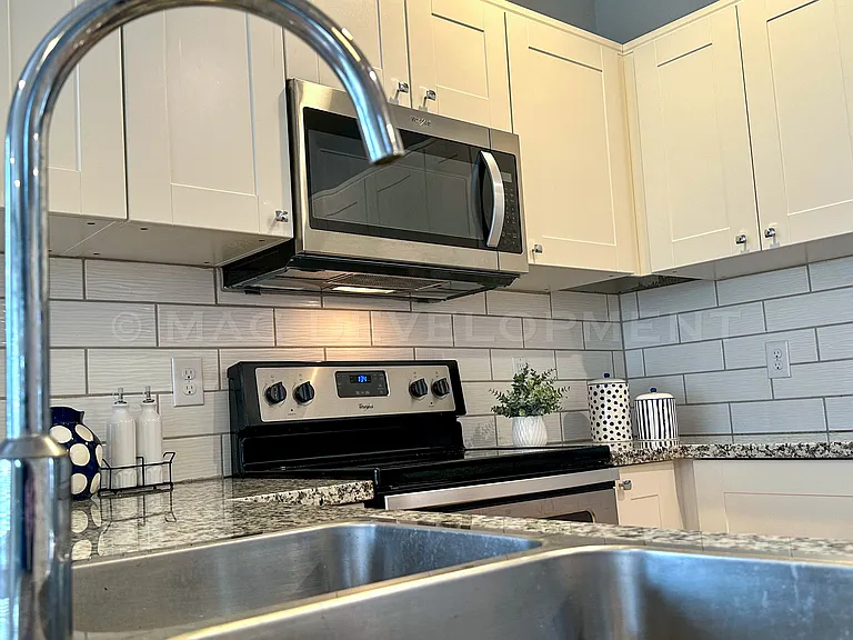 Stainless sink and faucet. Dishwasher to the left in lower cabinet.