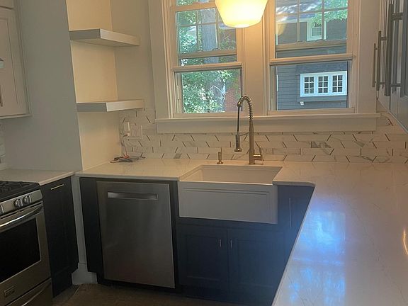 check out those counters and the farmhouse sink along with the dark blue cupboards