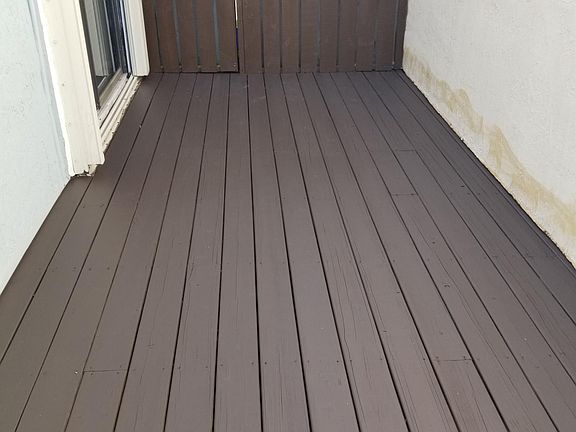 Deck extends around house lending to 3rd sliding glass door and gate to front area