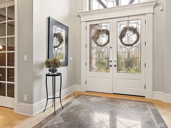 The leaded glass double door entry with timber beams leads to the 2 story foyer with marble inlaid floor.