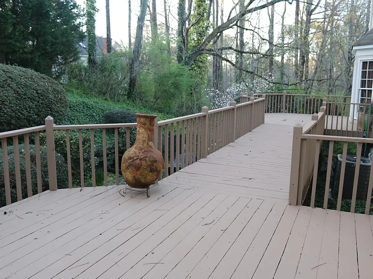 Large deck leads to short wooded walk to pool.