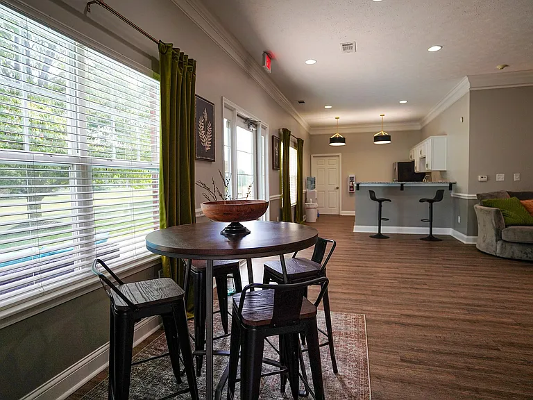 From morning meetups to casual hangs, this clubhouse space_with a high-top table and kitchen in view_is a go-to for laid-back connection.