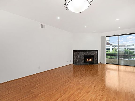 Living room, view 1 - from foyer with view of fireplace & balcony.