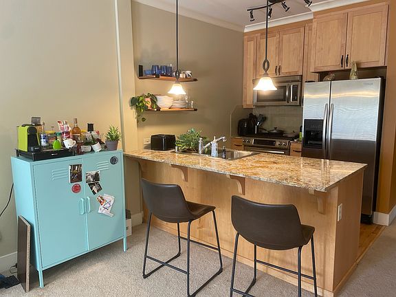Kitchen has breakfast bar, stainless appliances (including microwave and dishwasher).