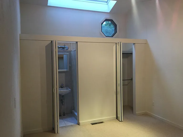 Bedroom north w skylight, door to bath, door to closet.
(Skylight brightness makes photo appear dark here)