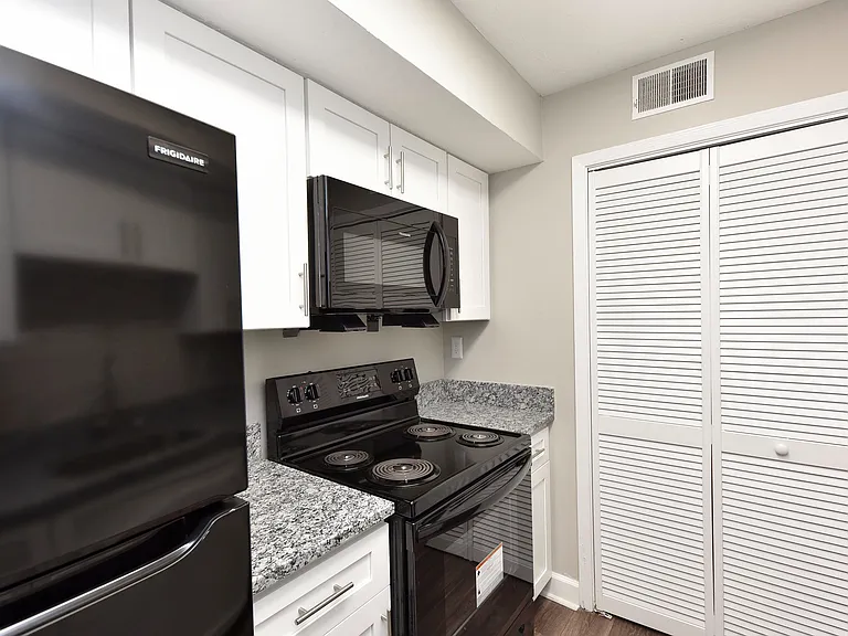 Kitchen with granite counters, modern cabinetry, and black appliances
