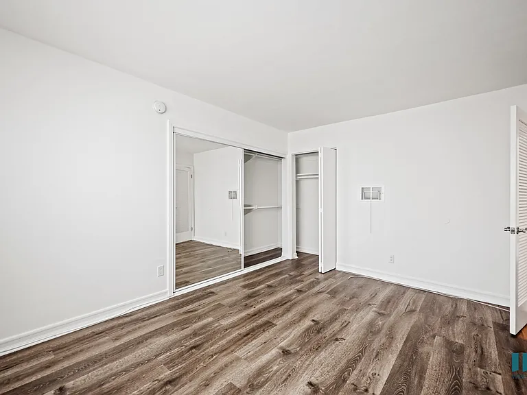 Bedroom with Vinly Flooring and Mirrored Closet