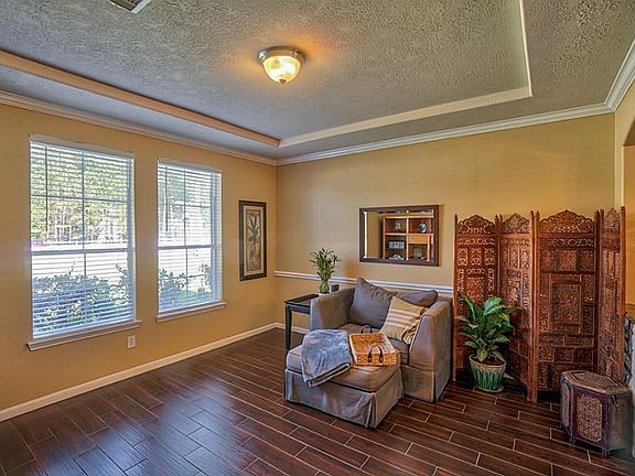 Formal living with tiered ceiling, and wood look tile floors!