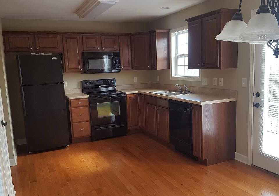 Kitchen with new refrigerator. Purchased only a couple months ago. Bright from natural light.