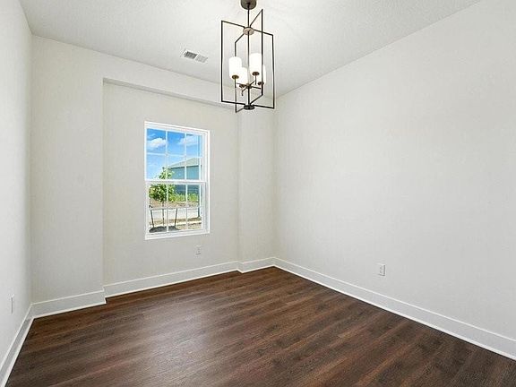 Recessed window frame with a single pane window, wood-finish flooring, white baseboards, and a contemporary chandelier