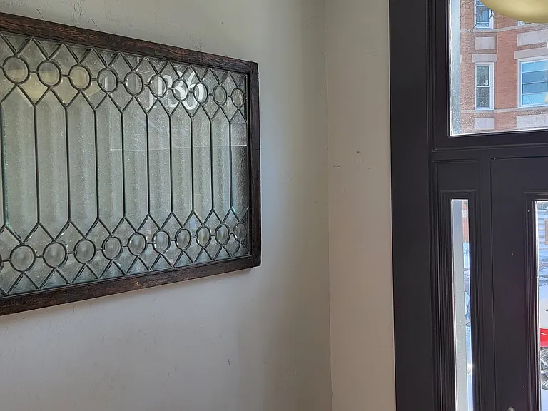 Restored lead glass front the original front entry door mounted as decor inside the foyer