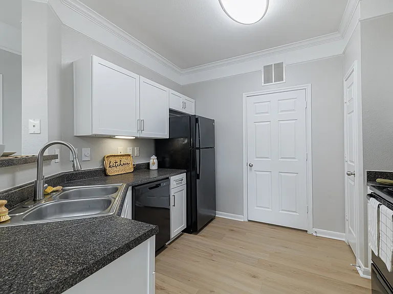 Kitchen with black appliances and white cabinetry