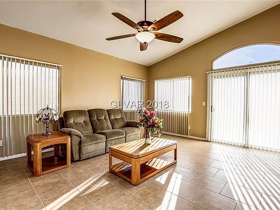 Living room with tile floors and ceiling fan..