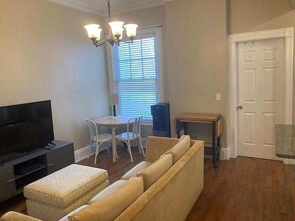 LR/DR with view to rear BR behind closed door; generous kitchen counter overhang visible - comfortable for 2 stools.