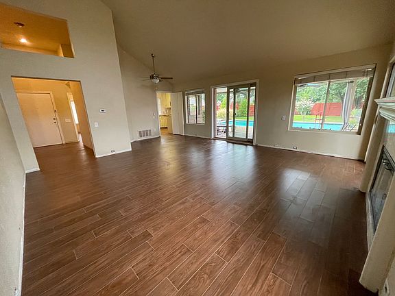 Living room with view to pool, front door entry and kitchen
