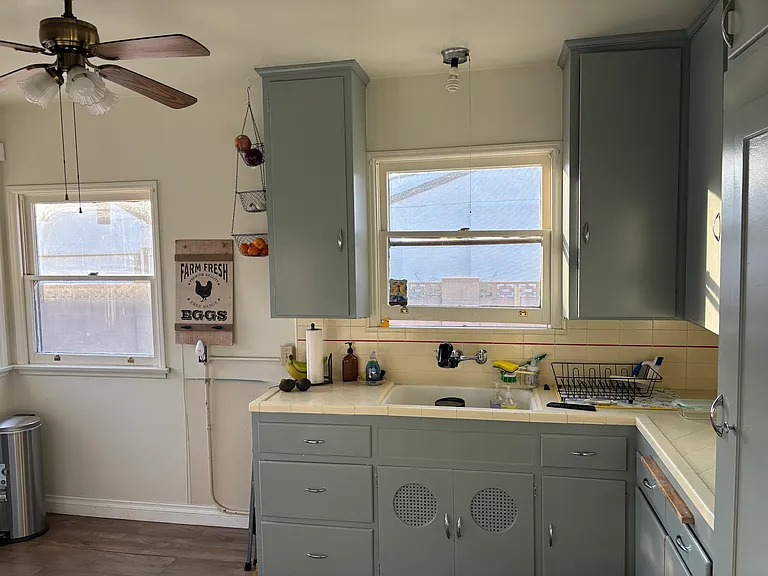 Classic 1930s-style kitchen featuring abundant natural light, timeless charm, and a large farmhouse sink.