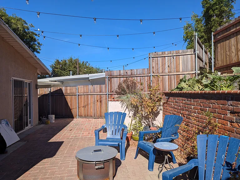 Backyard with fire pit and washer dryer unit.