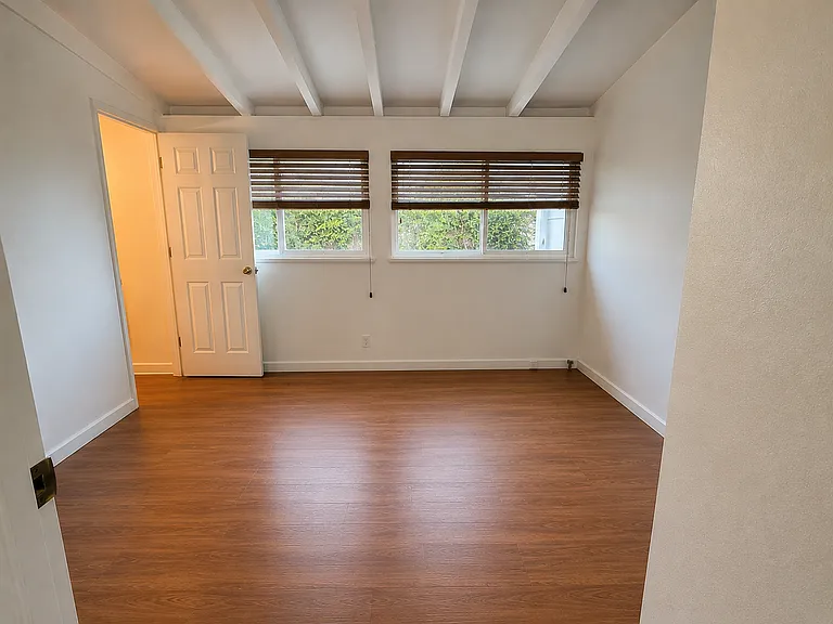 Clean and bright master room with wooden floors