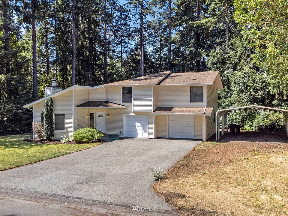 Surrounded by lush greenery, this home sits in a private setting.>