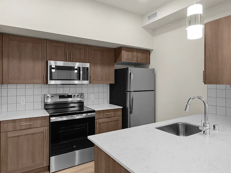 Modern in-home kitchen with stainless steel appliances and stylish wood cabinetry. Modern in-home kitchen with stainless steel appliances and stylish wood cabinetry.