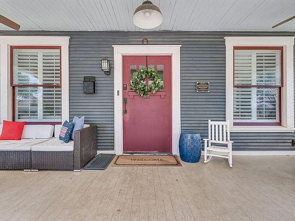Walk up the stairs to your extravagant front porch with your large red front door.