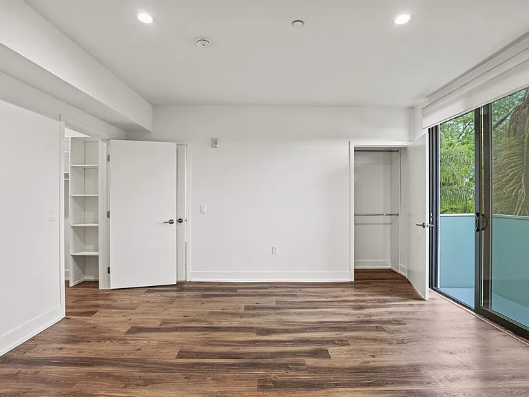 Bedroom with Two Closets, Vinyl Flooring, and Large-Size Patio