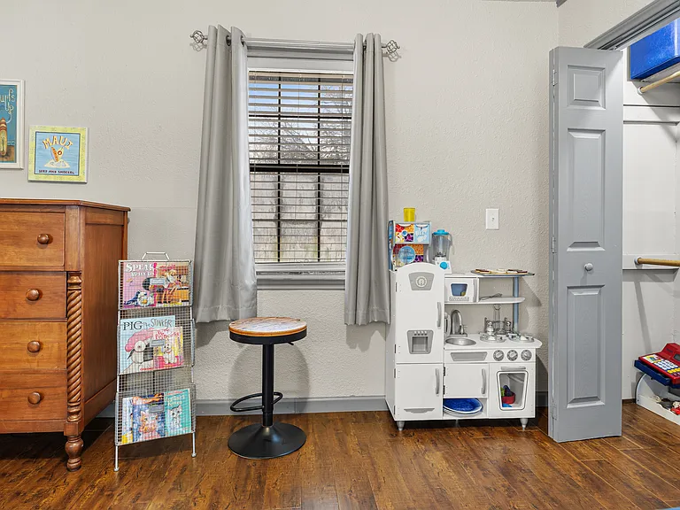 Dresser and play area with toys in secondary bedroom