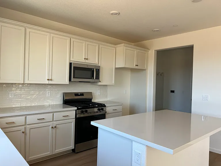 Kitchen to Pantry: Loads of counter space and cabinetry, plus a walk-in pantry just steps away. A home cook's dream.