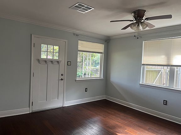 Front Door w/ large widows, natural light, and ceiling fan