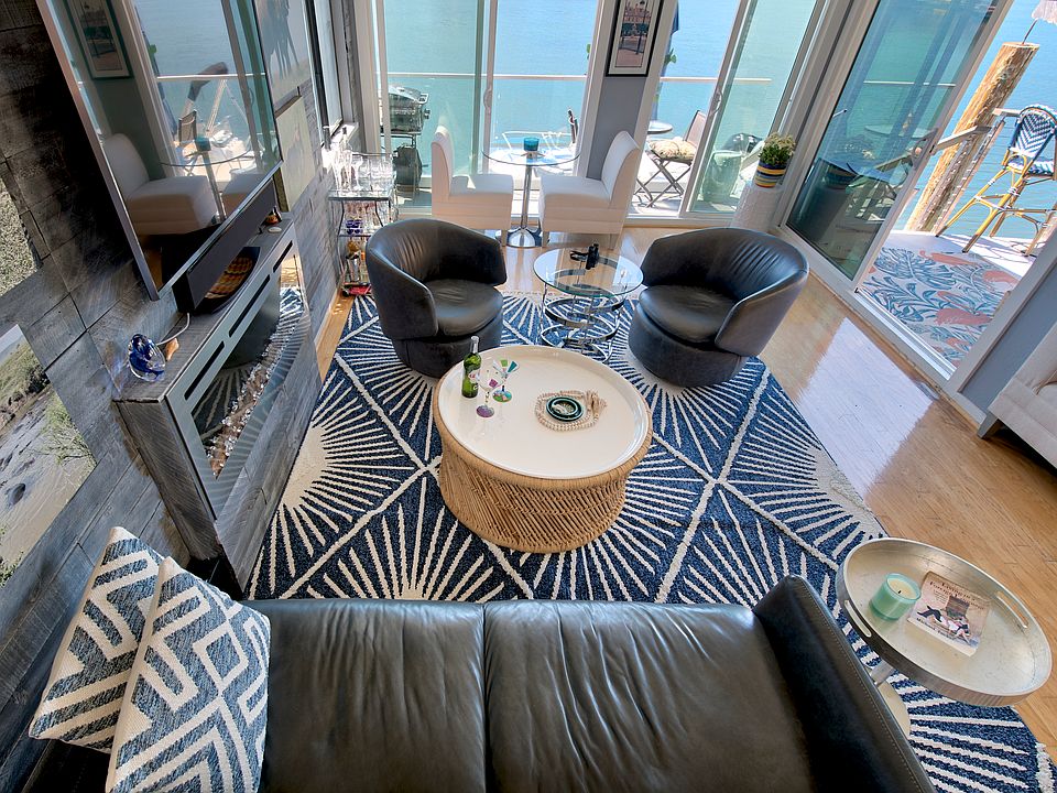 Living room from stairwell with wide open bay views from 3 sides.
