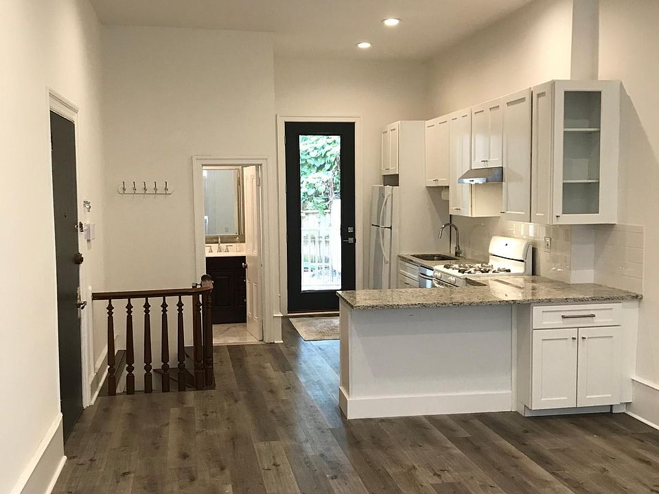Kitchen, bathroom on the left, Spiral Staircase going to lower floor, door to the private patio and backyard