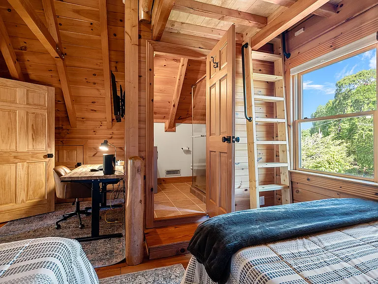 Upstairs bedroom includes a workspace and adjoining bathroom. The ladder leads to the loft space with the twin bed.