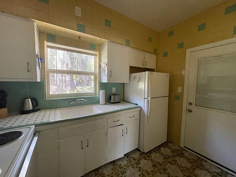 Kitchen leads to screened porch and laundry room.